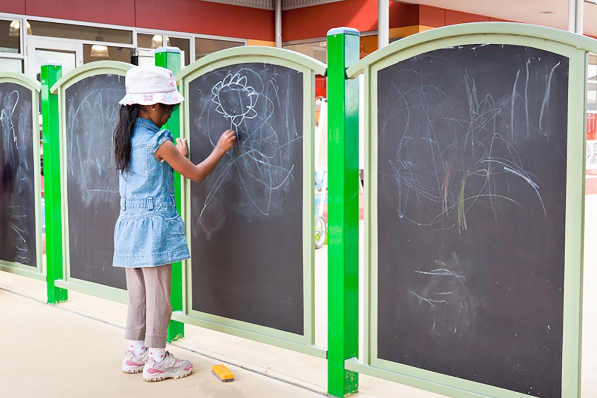A girl playing on the interactive chalkboards